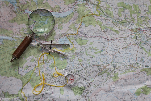 Une loupe et un compas posés sur une carte géographique